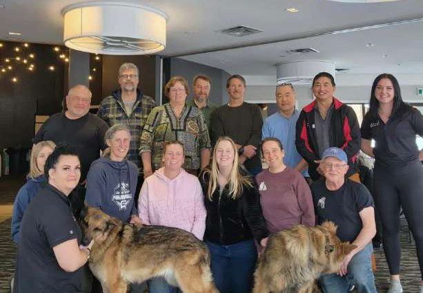 a group of people posing for a picture with a dog