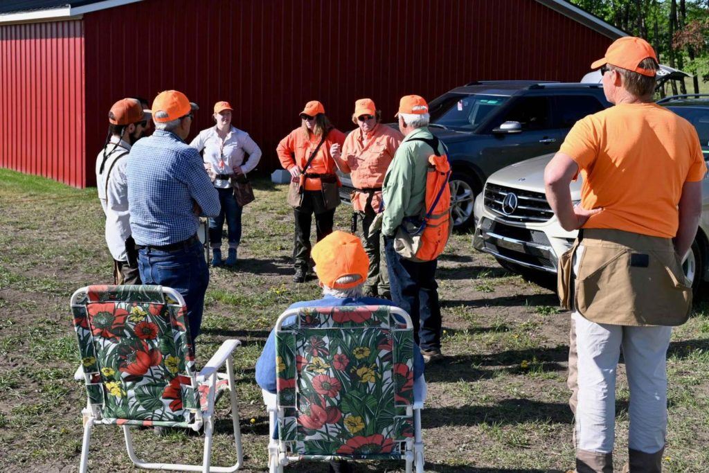 a group of people standing around each other in front of a barn