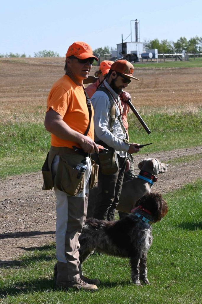 a couple of men standing next to a dog