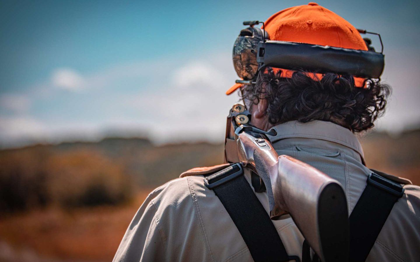 a man standing with a shotgun broken over his shoulder